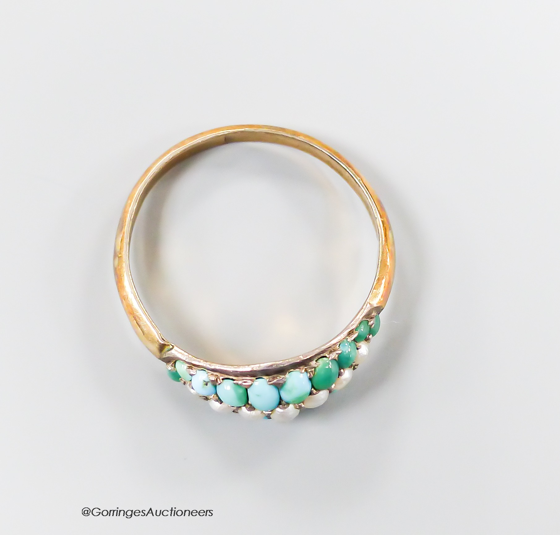 A yellow metal and graduated turquoise and seed pearl set three row half hoop ring, size R, gross 1.7 grams.